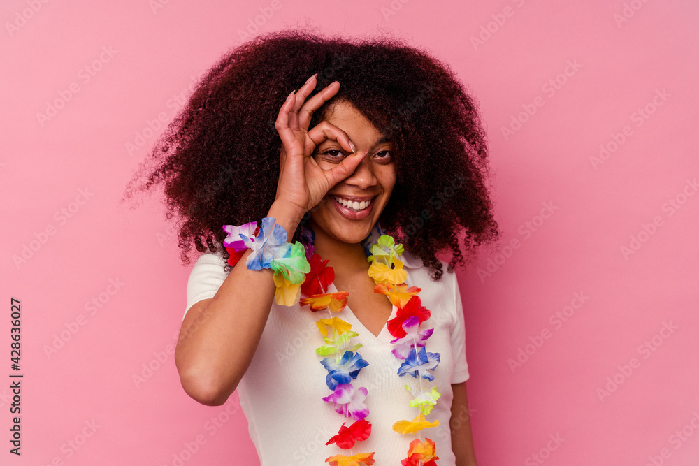 Young african american woman wearing a hawaiian stuff excited keeping ok gesture on eye. Young african american woman wearing a hawaiian stuff excited keeping ok gesture on eye.