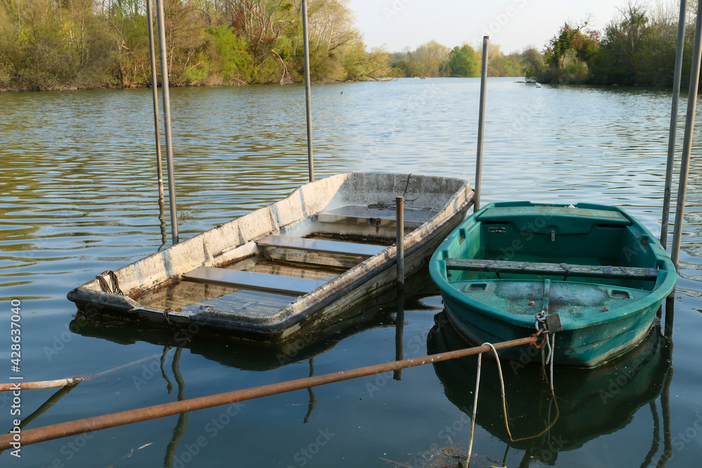 Abandoned rowing boat, isolated on a lake. Two wooden rowboat on water. Abandoned rowing boat, isolated on a lake. Two wooden rowboat on water.