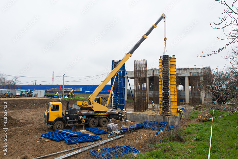 Construction of reinforced concrete columns of a transport bridge using a truck crane. Construction of reinforced concrete columns of a transport bridge using a truck crane.