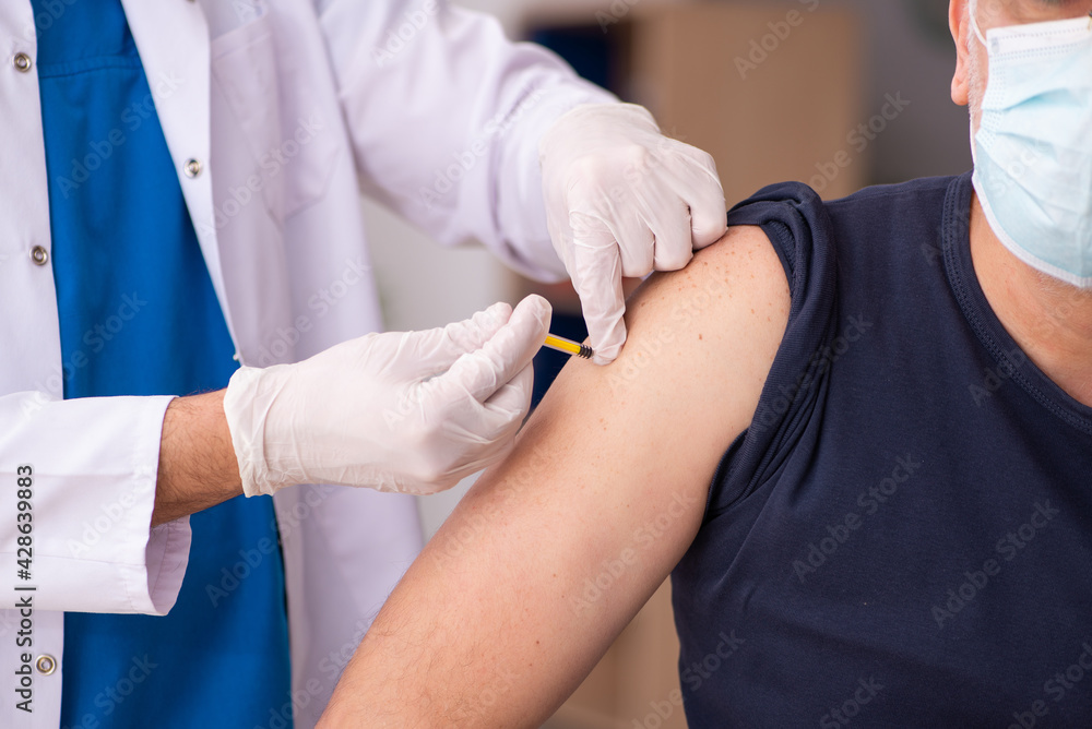 Old man visiting young doctor in covid-19 vaccination concept Old man visiting young doctor in covid-19 vaccination concept