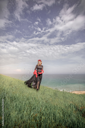 girl standing on a hill by the sea