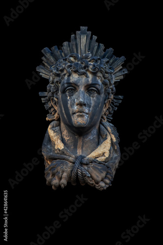 An ancient stone statue of God of Sun and sight Helios (Helius). Fragment of an ancient statue. Often he is depicted with a radiant crown.