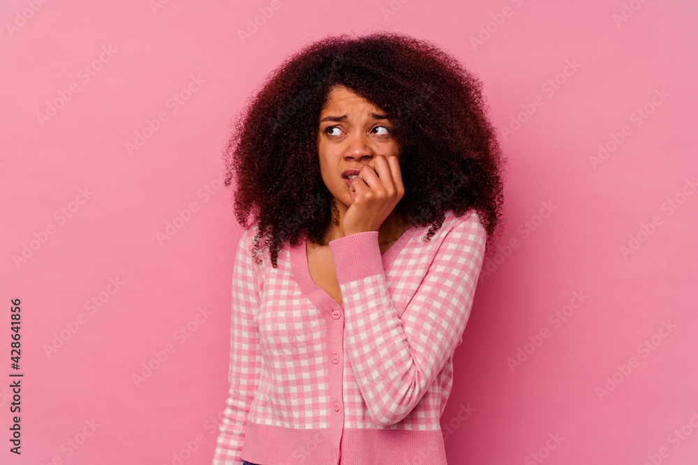 Young african american woman isolated on pink background biting fingernails, nervous and very anxious. Young african american woman isolated on pink background biting fingernails, nervous and very anxious.