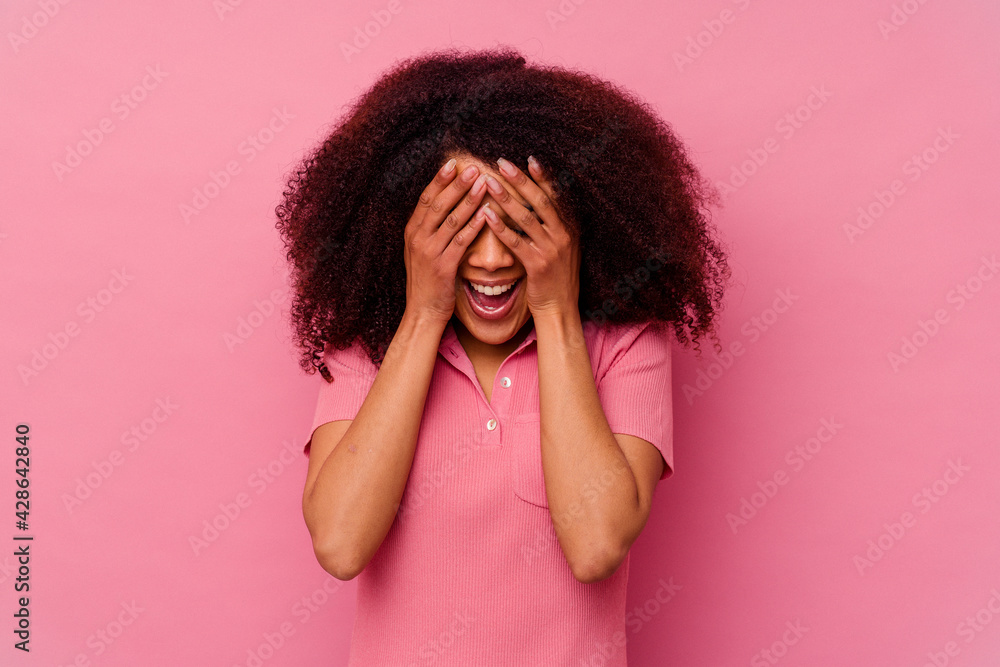 Young african american woman isolated on pink background covers eyes with hands, smiles broadly waiting for a surprise. Young african american woman isolated on pink background covers eyes with hands, smiles broadly waiting for a surprise.