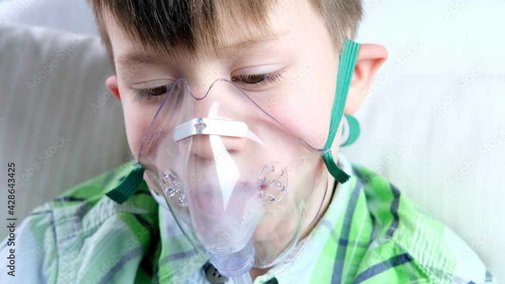 little patient in shirt, child, boy lies, facial oxygen mask, concept of medical care, anesthesiology and intensive care, oxygen therapy, treatment of coronavirus, COVID-19