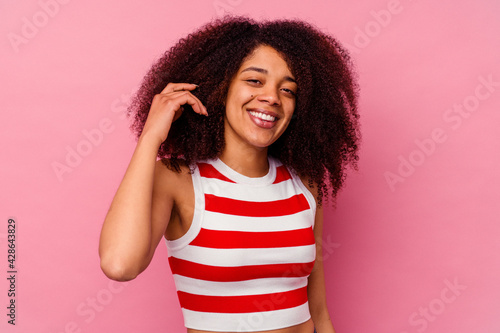 Young african american woman isolated on pink background laughing about something, covering mouth with hands.