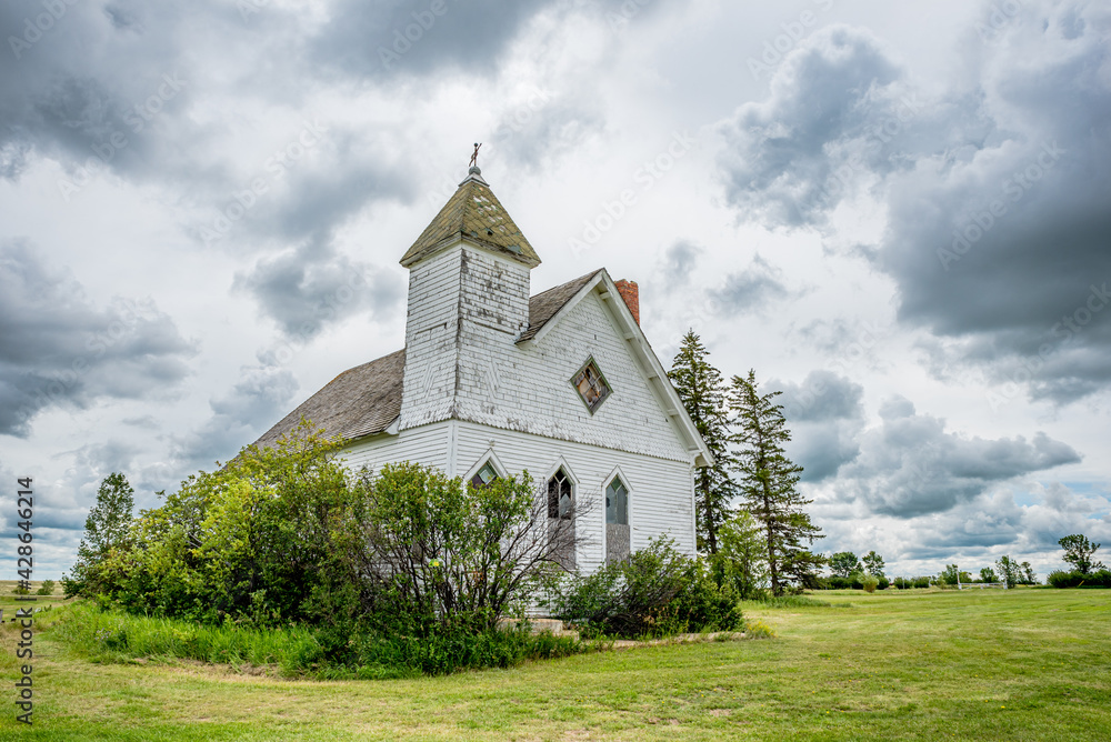 Dramatic sky over the historic yet abandoned Trossachs United Church in Trossachs, SK