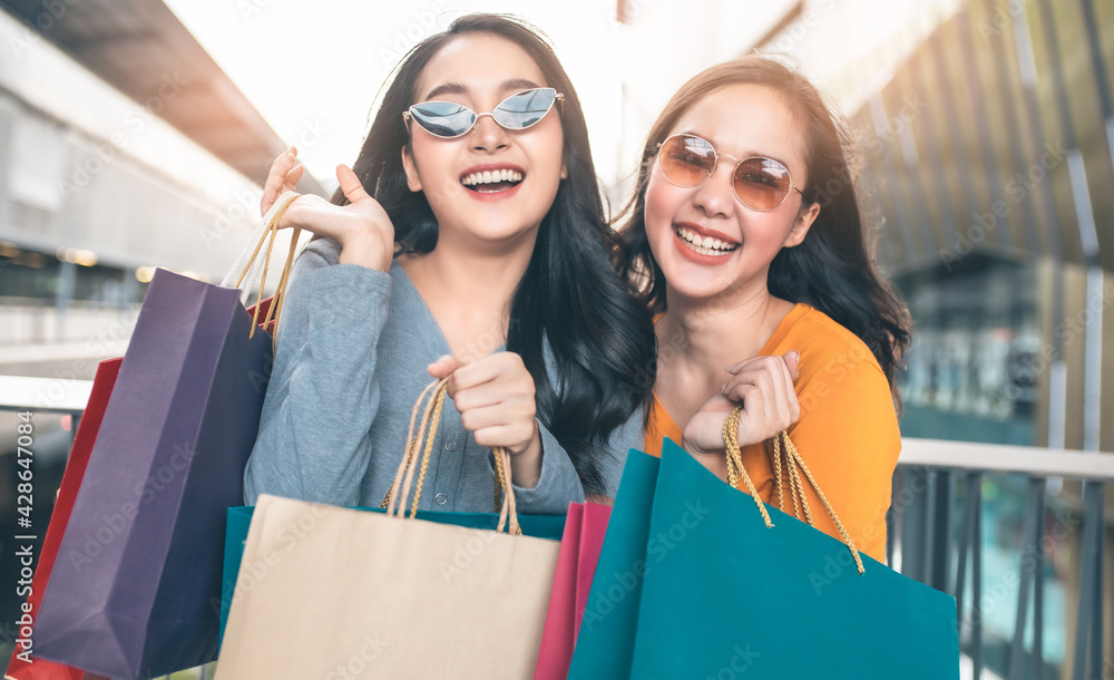 Happy woman with shopping bags enjoying in shopping. Girl holding colour paper bag.Friends walking in shopping mall.time shopping coronavirus crisis or covid19 outbreak. Happy woman with shopping bags enjoying in shopping. Girl holding colour paper bag.Friends walking in shopping mall.time shopping coronavirus crisis or covid19 outbreak.