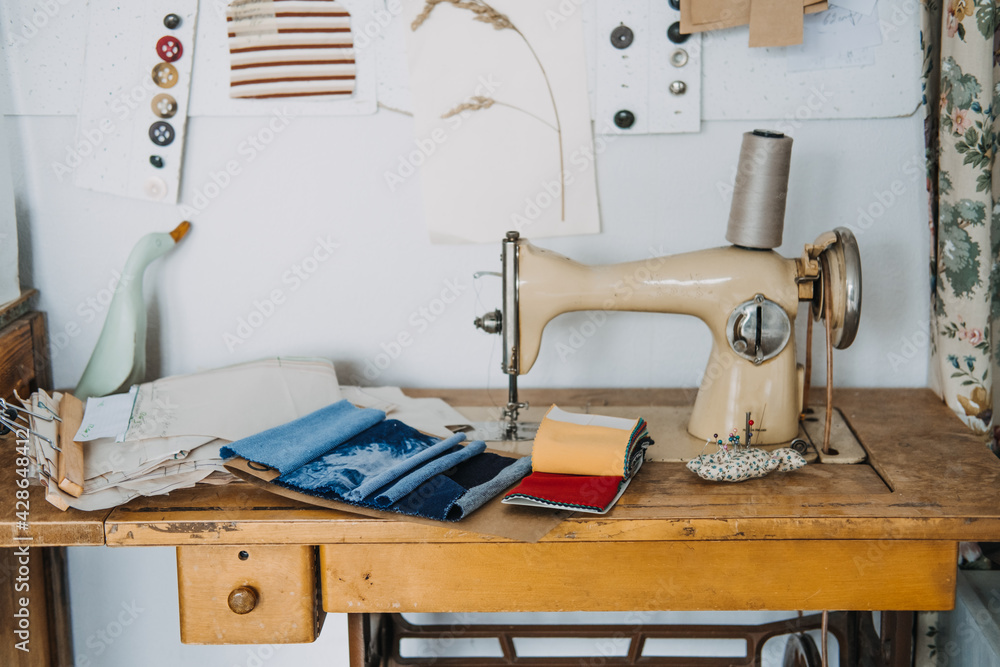 Supporting local, Tailoring small business. Seamstress, dressmaker, designer retro style workplace. Sewing machine with fabric samples, Threads and needles.