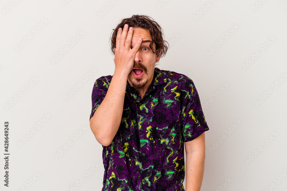 Young caucasian man isolated on white background having fun covering half of face with palm. Young caucasian man isolated on white background having fun covering half of face with palm.