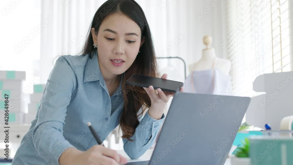 Asian entreprenuer woman online seller confirming orders from customer on the phone. Online web store owner taking order on phone, texting message online. Phone call receive from customer Asian entreprenuer woman online seller confirming orders from customer on the phone. Online web store owner taking order on phone, texting message online. Phone call receive from customer