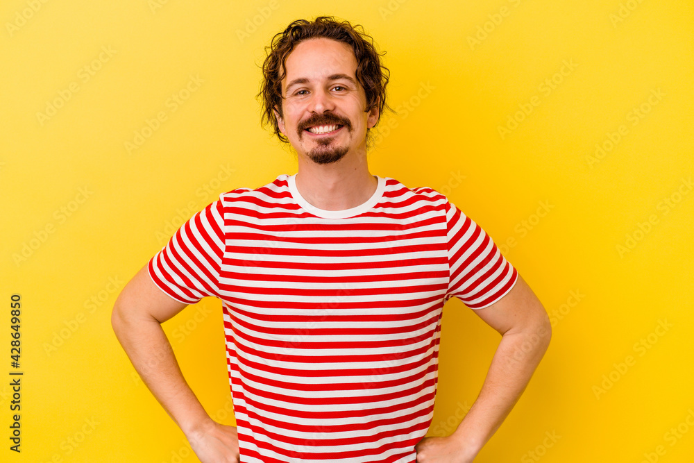 Young caucasian man isolated on yellow background confident keeping hands on hips. Young caucasian man isolated on yellow background confident keeping hands on hips.