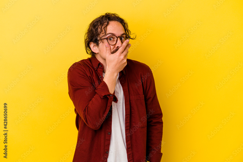 Young caucasian man isolated on yellow background scared and afraid.