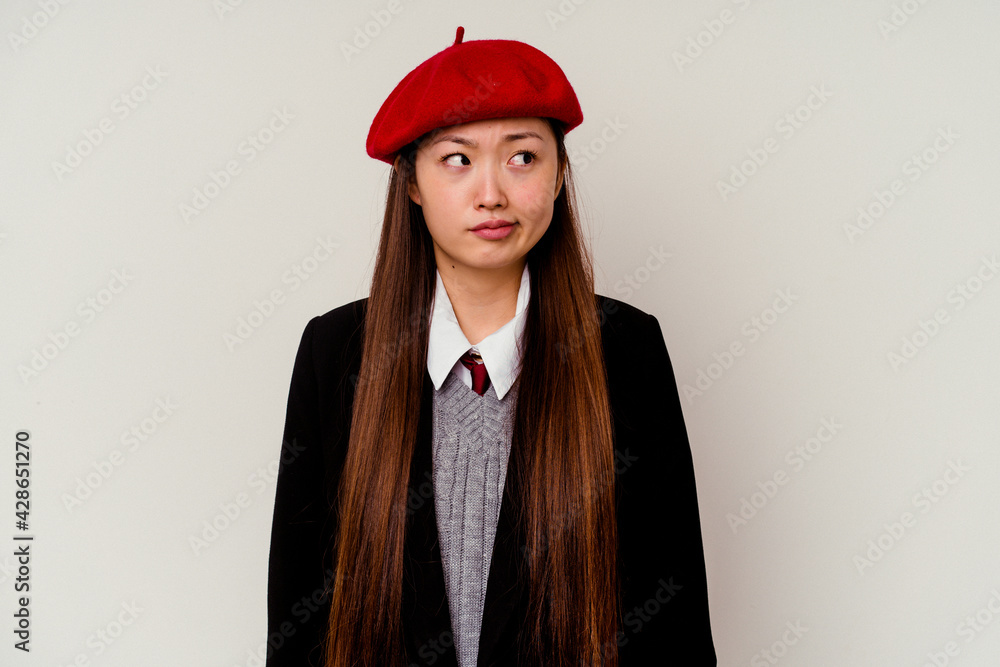 Young chinese woman wearing a school uniform isolated on white background confused, feels doubtful and unsure. Young chinese woman wearing a school uniform isolated on white background confused, feels doubtful and unsure.