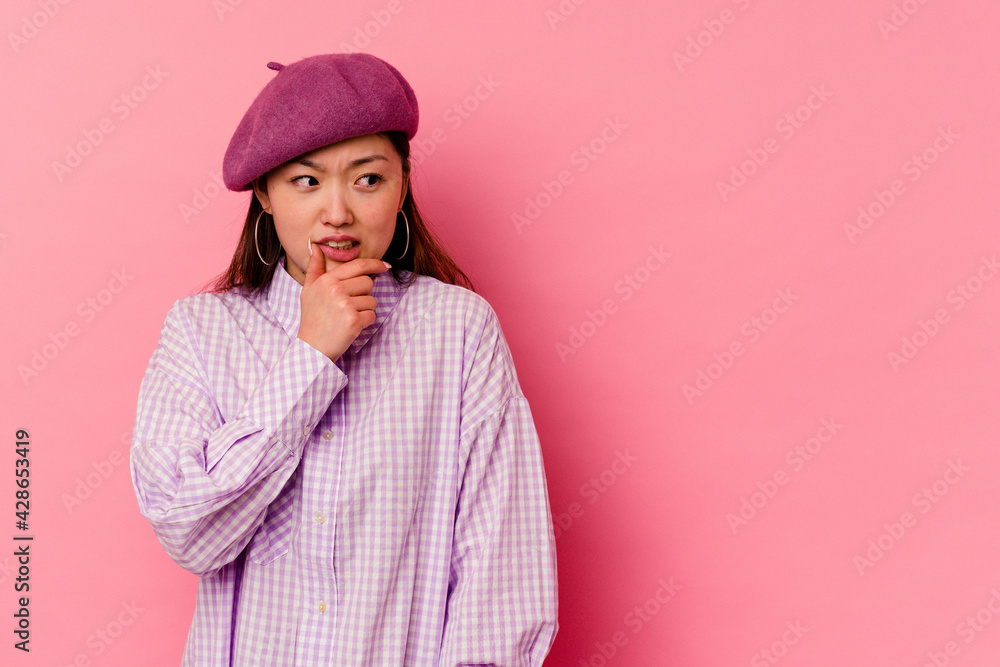 Young chinese woman isolated on pink background touching back of head, thinking and making a choice. Young chinese woman isolated on pink background touching back of head, thinking and making a choice.