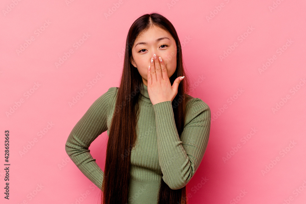 Young chinese woman isolated on pink background shocked, covering mouth with hands, anxious to discover something new. Young chinese woman isolated on pink background shocked, covering mouth with hands, anxious to discover something new.