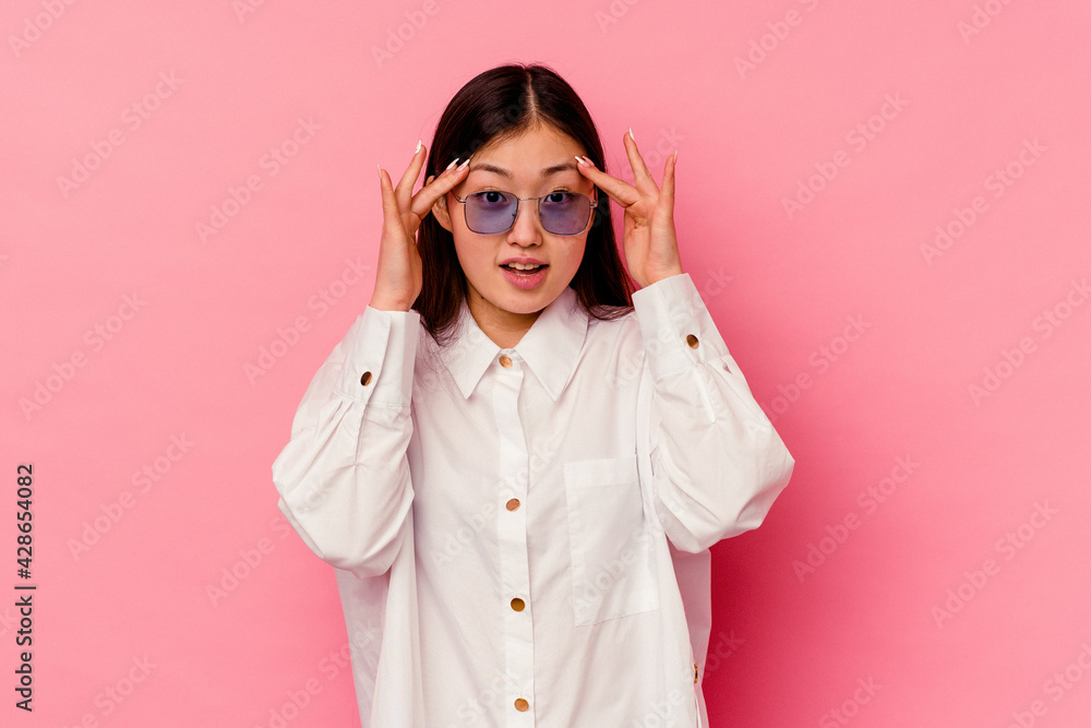 Young chinese woman isolated on pink background receiving a pleasant surprise, excited and raising hands. Young chinese woman isolated on pink background receiving a pleasant surprise, excited and raising hands.