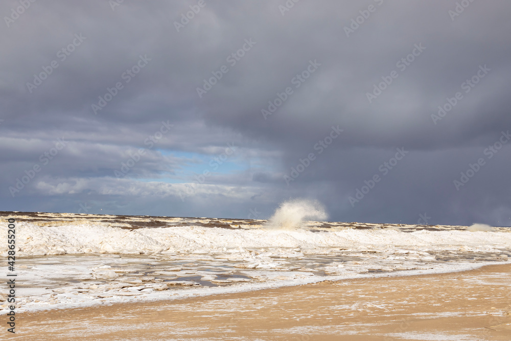 Winter coastal seascape with floating ice fragments on still cold water. Baltic Sea