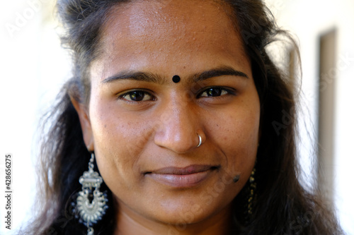 Closeup portrait of a young Indian woman with a bindi on her forehead looking at the camera photo