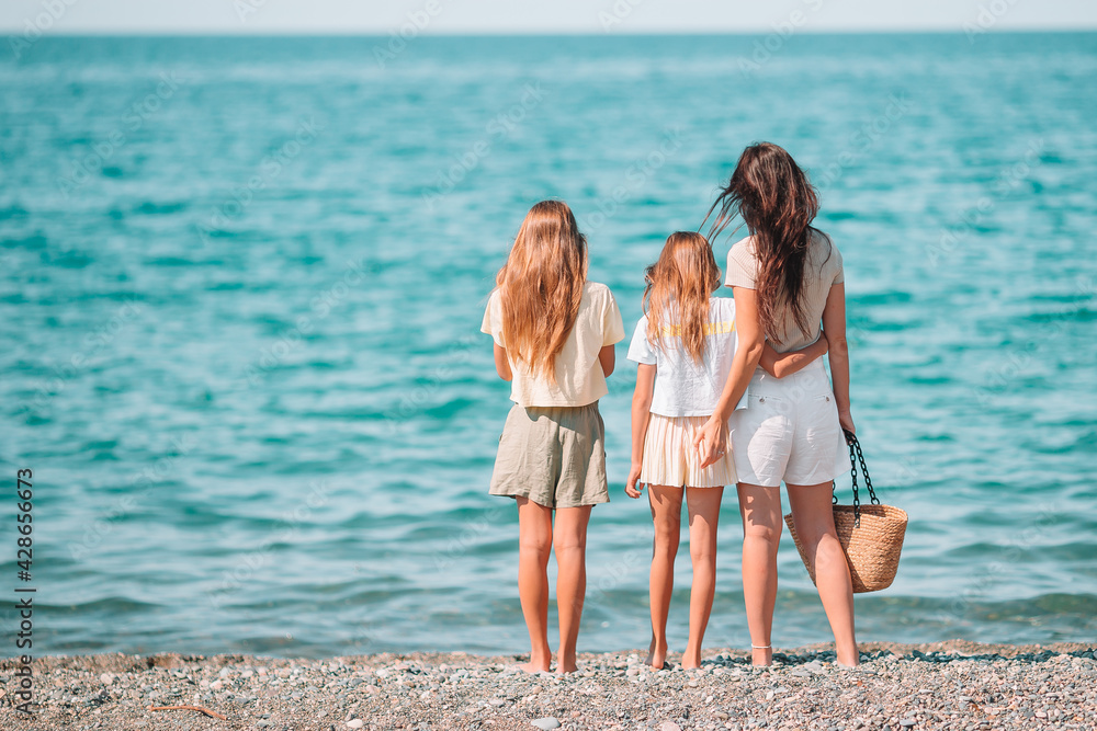 Adorable little girls and young mother on tropical white beach Adorable little girls and young mother on tropical white beach