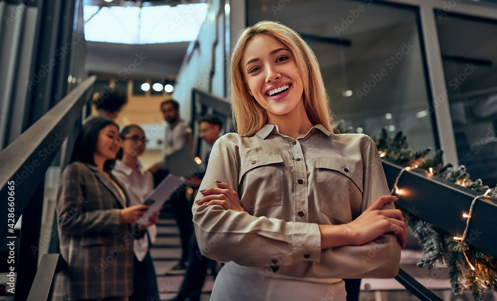 Fototapeta premium Beautiful business woman smiling looking at camera, arms crossed standing in the office. Business concept.