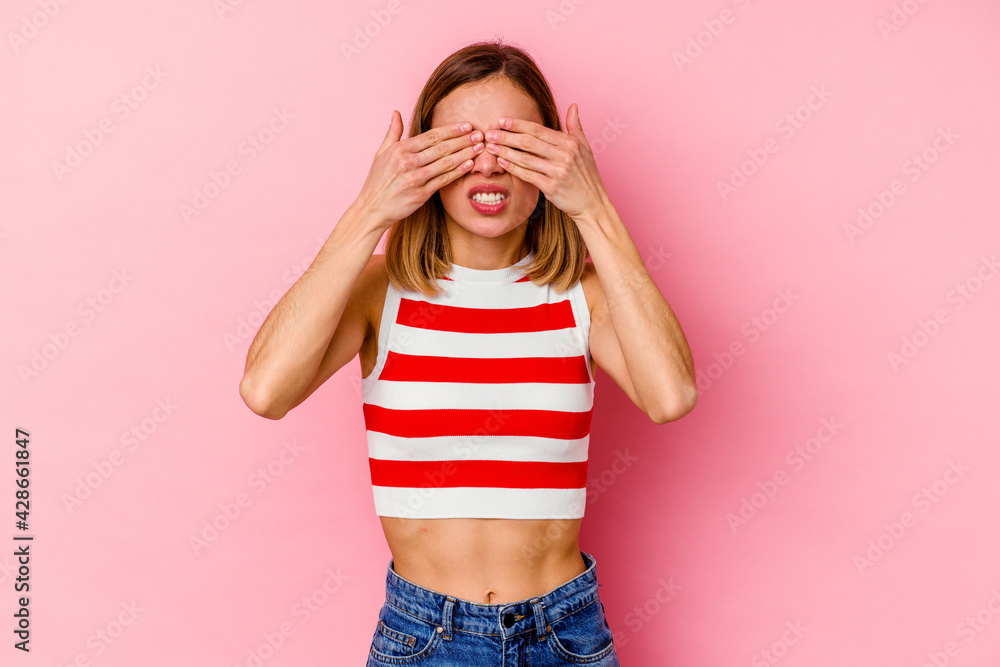 Young caucasian woman isolated on pink background afraid covering eyes with hands. Young caucasian woman isolated on pink background afraid covering eyes with hands.