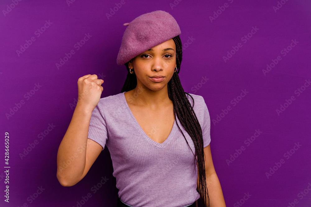 Naklejka premium Young african american woman isolated on yellow background Young african american woman isolated on yellow background showing fist to camera, aggressive facial expression.