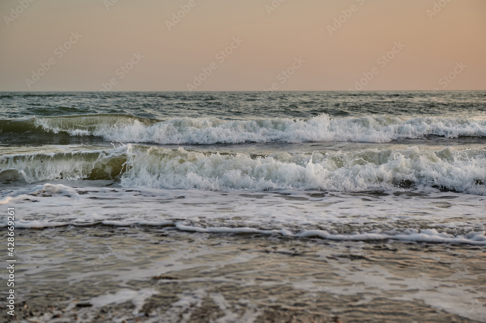 waves on the black sea at sunset