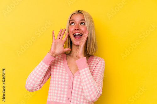 Young venezuelan woman isolated on yellow background shouting excited to front.