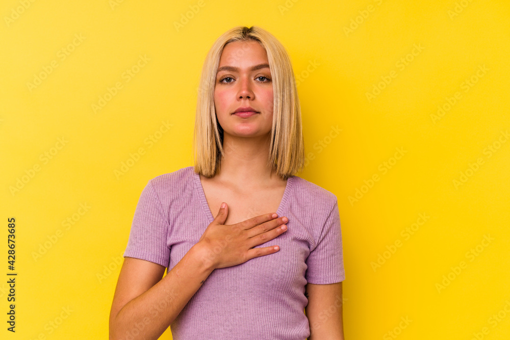 Young venezuelan woman isolated on yellow background taking an oath, putting hand on chest. Young venezuelan woman isolated on yellow background taking an oath, putting hand on chest.