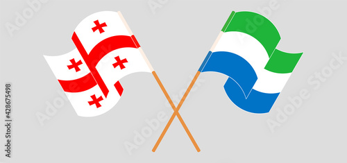 Crossed and waving flags of Georgia and Sierra Leone