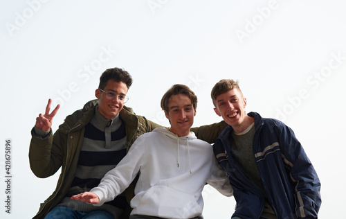 A closeup of three young Caucasian and Hispanic friends hanging out outdoors