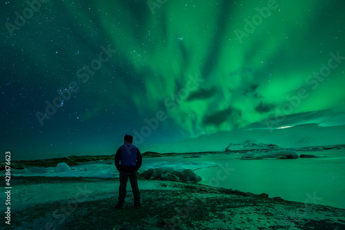 a man from the back watching the northern lights. Aurora borealis. 