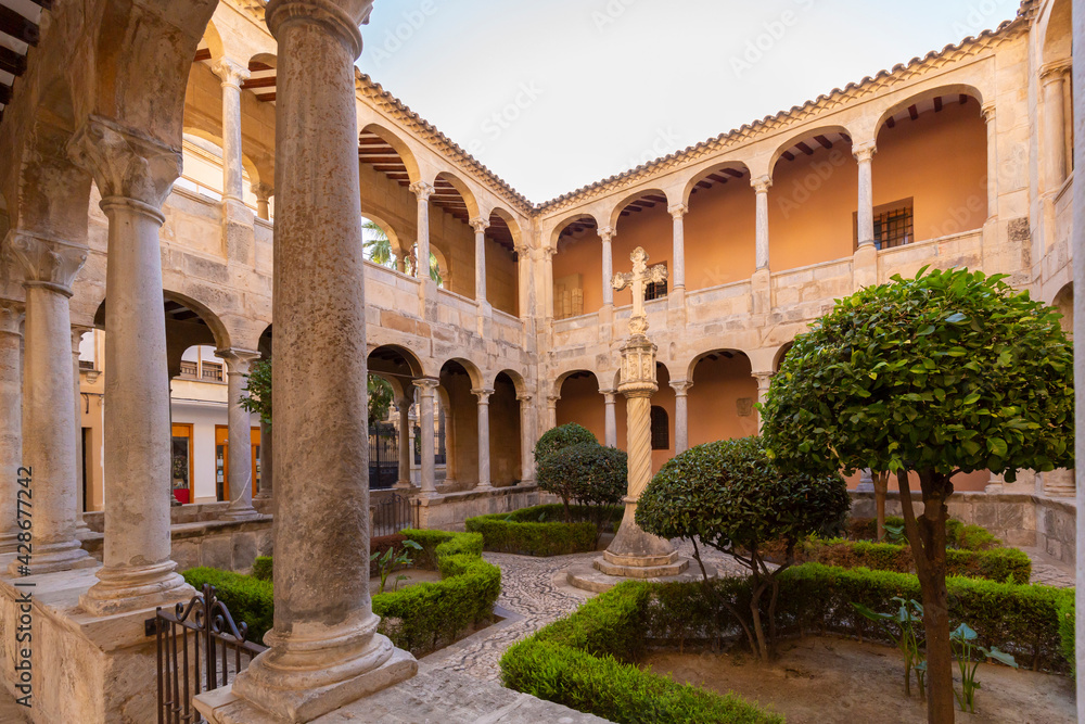 The courtyard of the Monastery of the Sacred Cathedral of El Salvador with a stone cross in the city of Orihuela on the Costa Blanca in Spain.