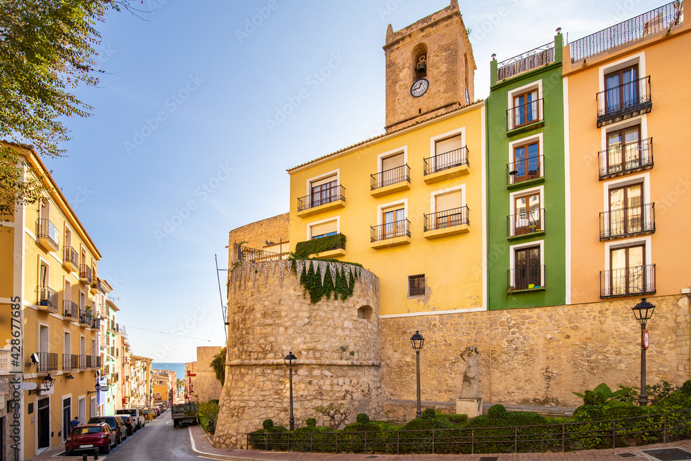 Colored houses on a stone fortress wall and tower of the old town of Villajoyosa Spain