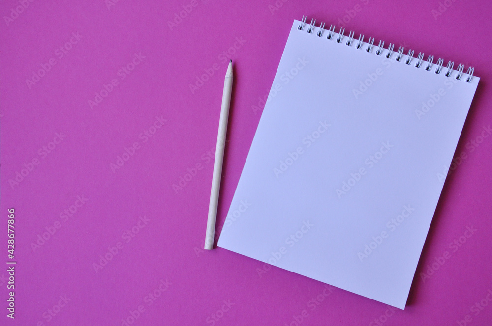 Blanc spiral school notepad with pencil. Top view notepad on color pink background Blanc spiral school notepad with pencil. Top view notepad on color pink background