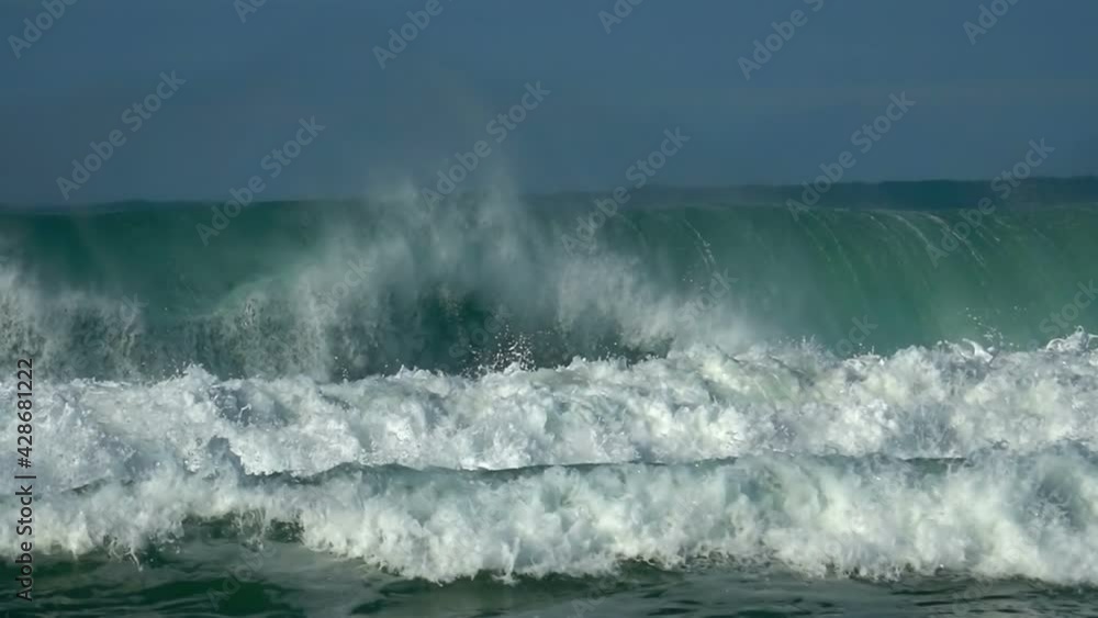 Ocean, green wave splashing. Win waves sea-spray, water foam. Blue sky Ocean, green wave splashing. Win waves sea-spray, water foam. Blue sky