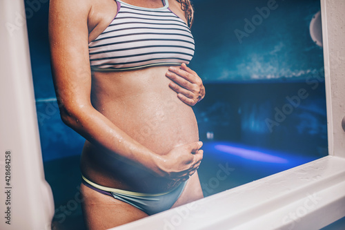 Papier peint Beautiful pregnant woman in tank filled with dense salt water used in meditation, therapy, and alternative medicine