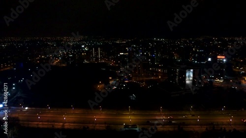  Aerial view on Nauky Ave street and multistorey modern high buildings at night. Cars driving illuminated night road in Kharkiv city center cityscape photo