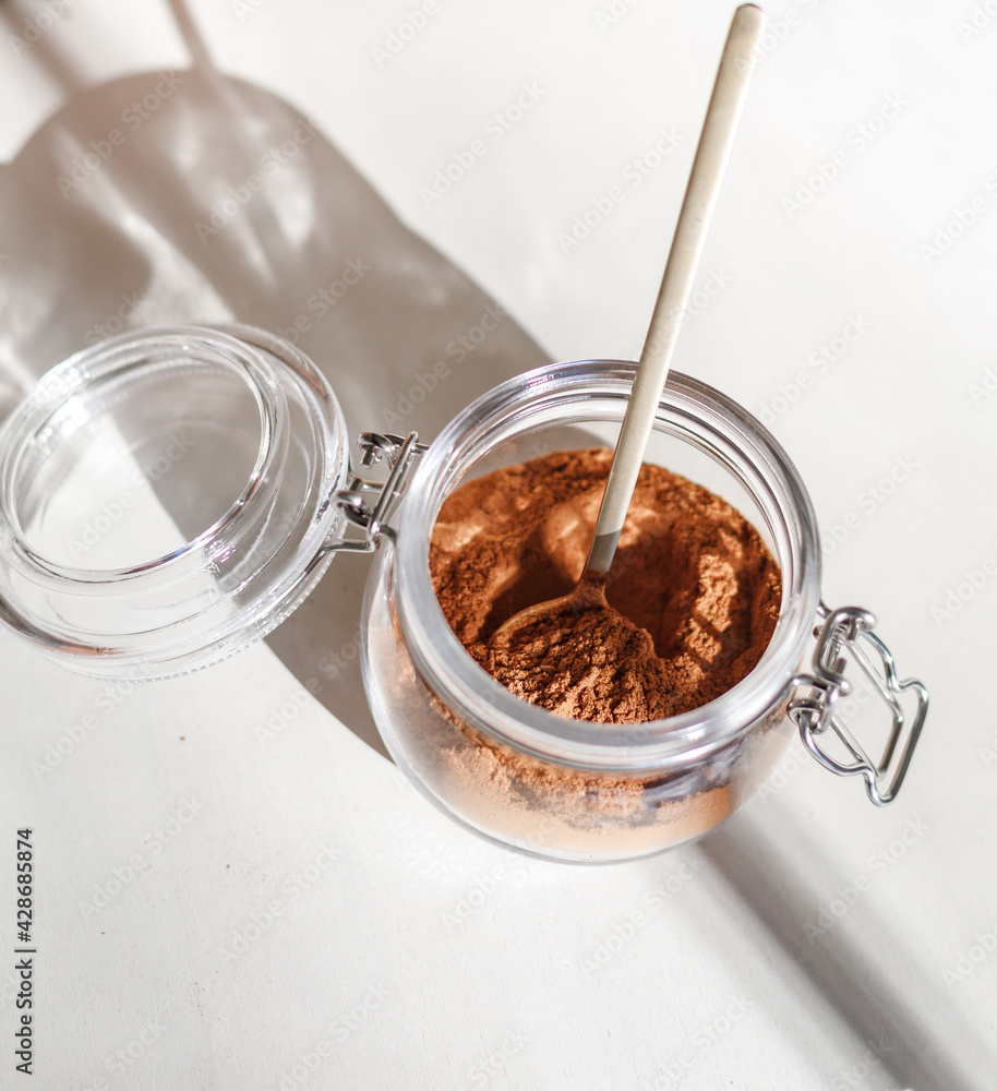cinnamon powder in glass jar with a golden spoon cinnamon powder in glass jar with a golden spoon