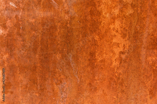 Smooth, slightly rough weathered and rusted orange-red colors surface with rust runs and rust spots. Detailed closeup Rusted metal sheet texture