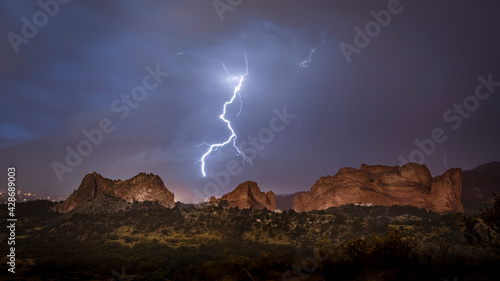 Lighting from a thunderstorm strikes inside Garden of the Gods State park at night in Colorado Springs Colorado during the summer. This is a popular tourist destination for vacations. 