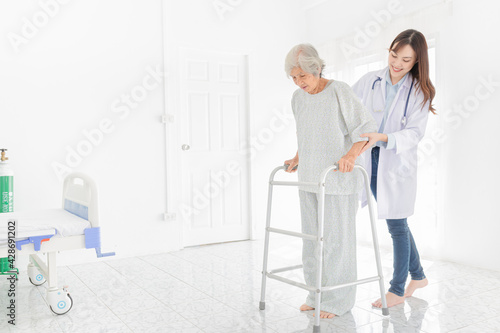 walk training and rehabilitation process, old asian stroke patient learning to uses walker with female asian doctor in hospital, elderly healthcare promotion © jokekung