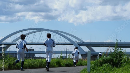 河川敷のジョギングコースのリトルリーグの少年達