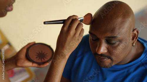 Slika na platnu handsome black man sits calmly as assistant does touch-up