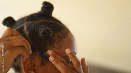 close up of a young woman laying her hair edges down