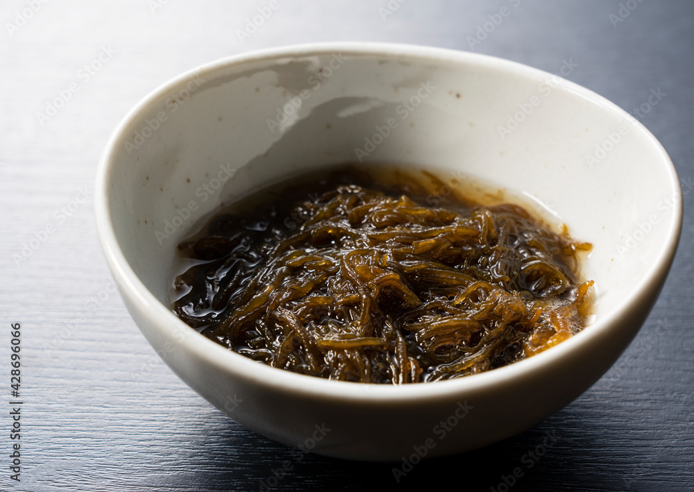 A mozuku seaweed placed on a black background. A mozuku seaweed placed on a black background.