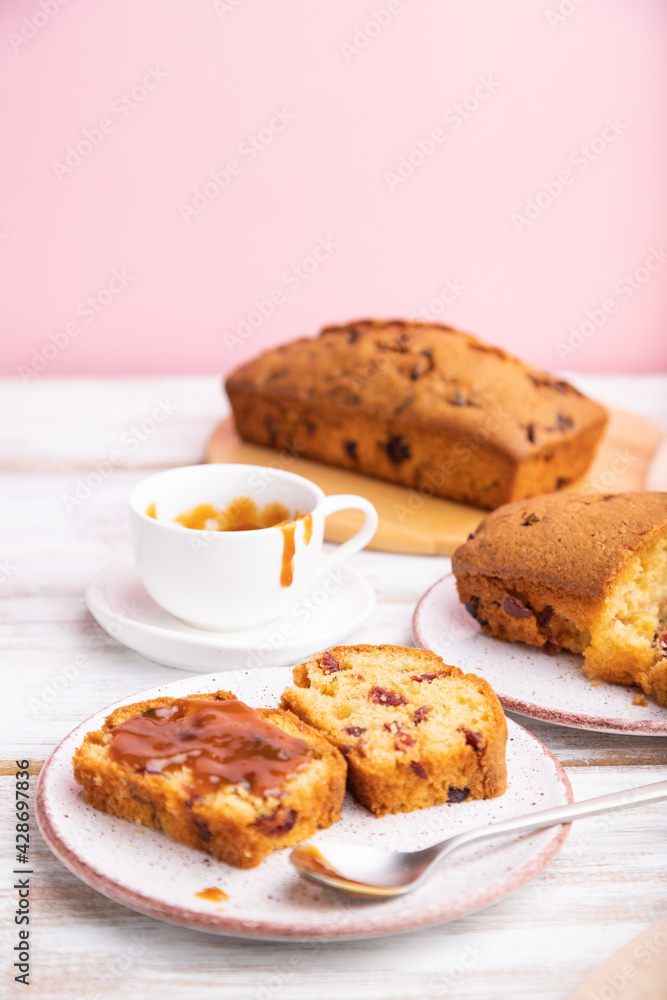 Homemade cake with raisins, almonds, soft caramel on a white and pink background.  Side view, selective focus.