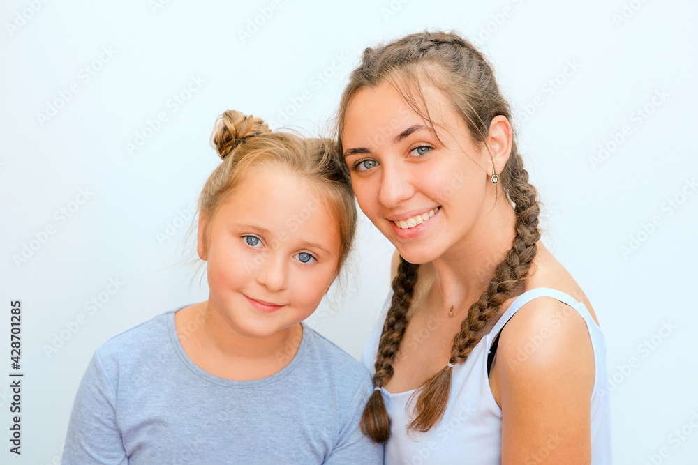 Portrait of two nice adorable winsome pretty cheerful cheery sisters on white isolated background Portrait of two nice adorable winsome pretty cheerful cheery sisters on white isolated background