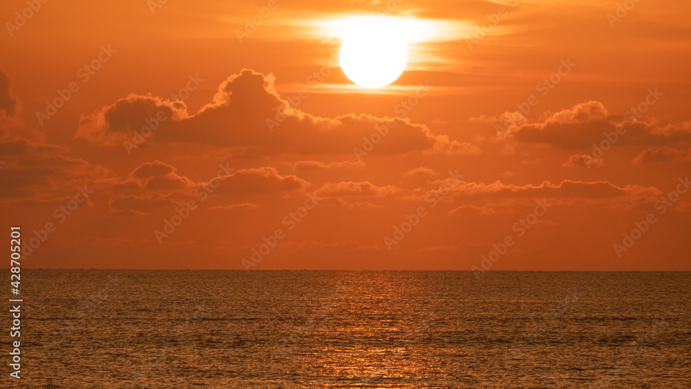 Beautiful sunrise or sunset over the ocean in summer. Gold sky with sunlight and clound above the sea. Nature, landscape, seascape background.